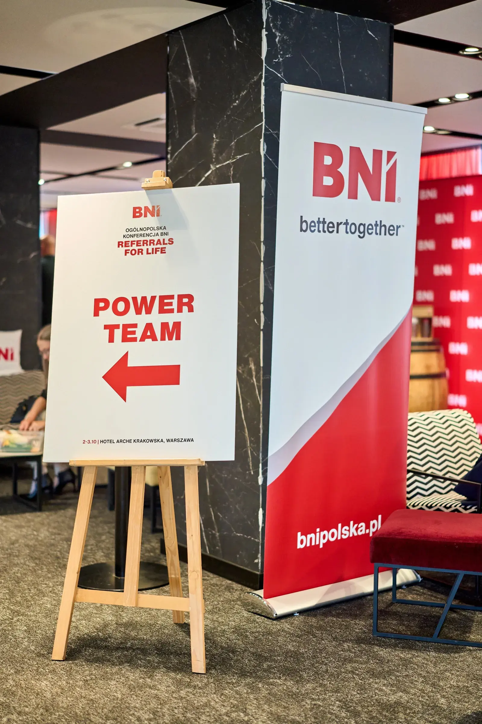 Tablica ze strzałką na sesję Power Team i roll-up BNI w holu hotelu
