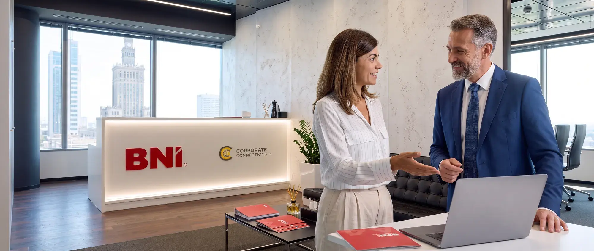 Pracowniczka Biura Narodowego rozmawia z gościem przy recepcji BNI